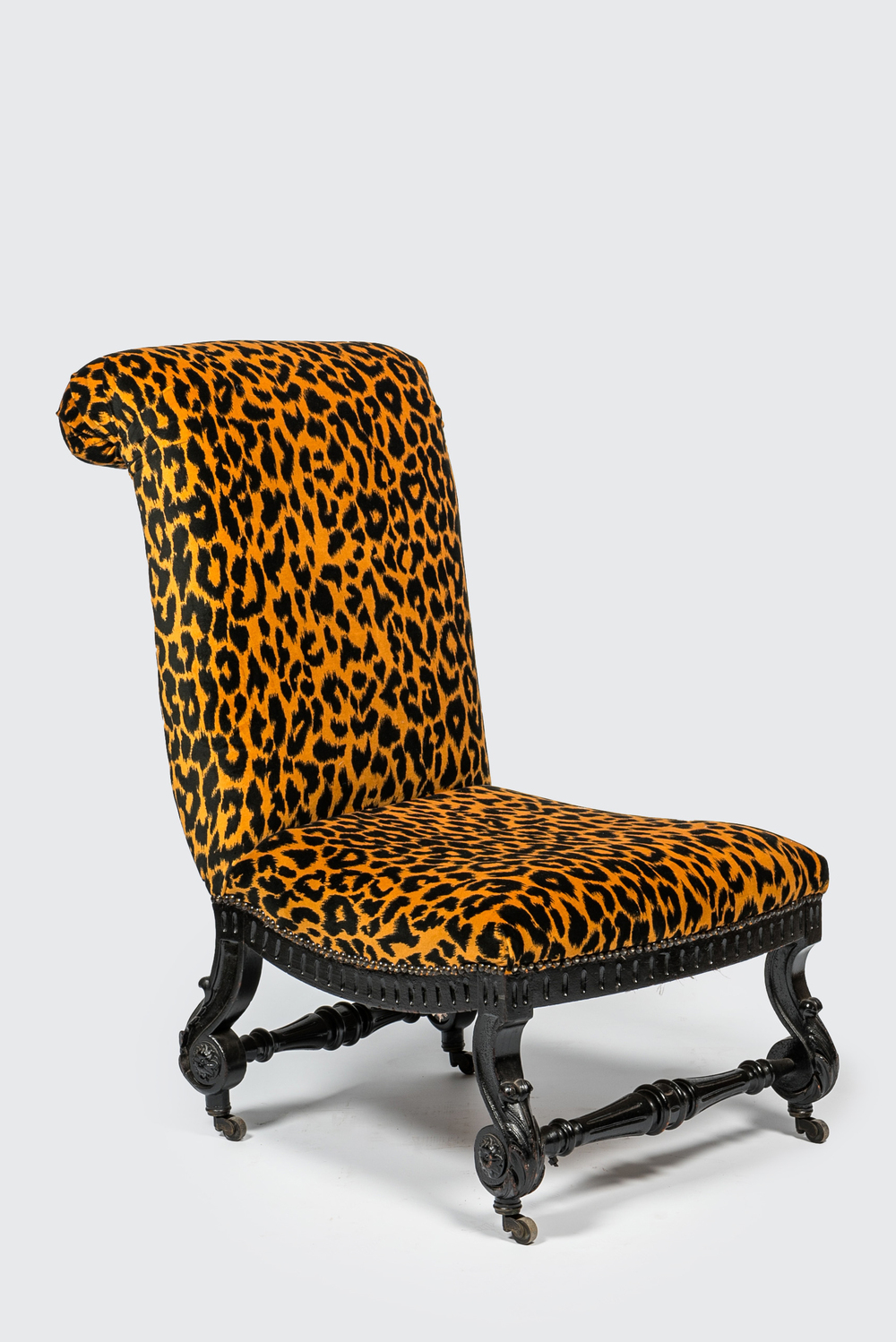An ebonised wooden 'leopard design' chair on wheels, 19/20th C.