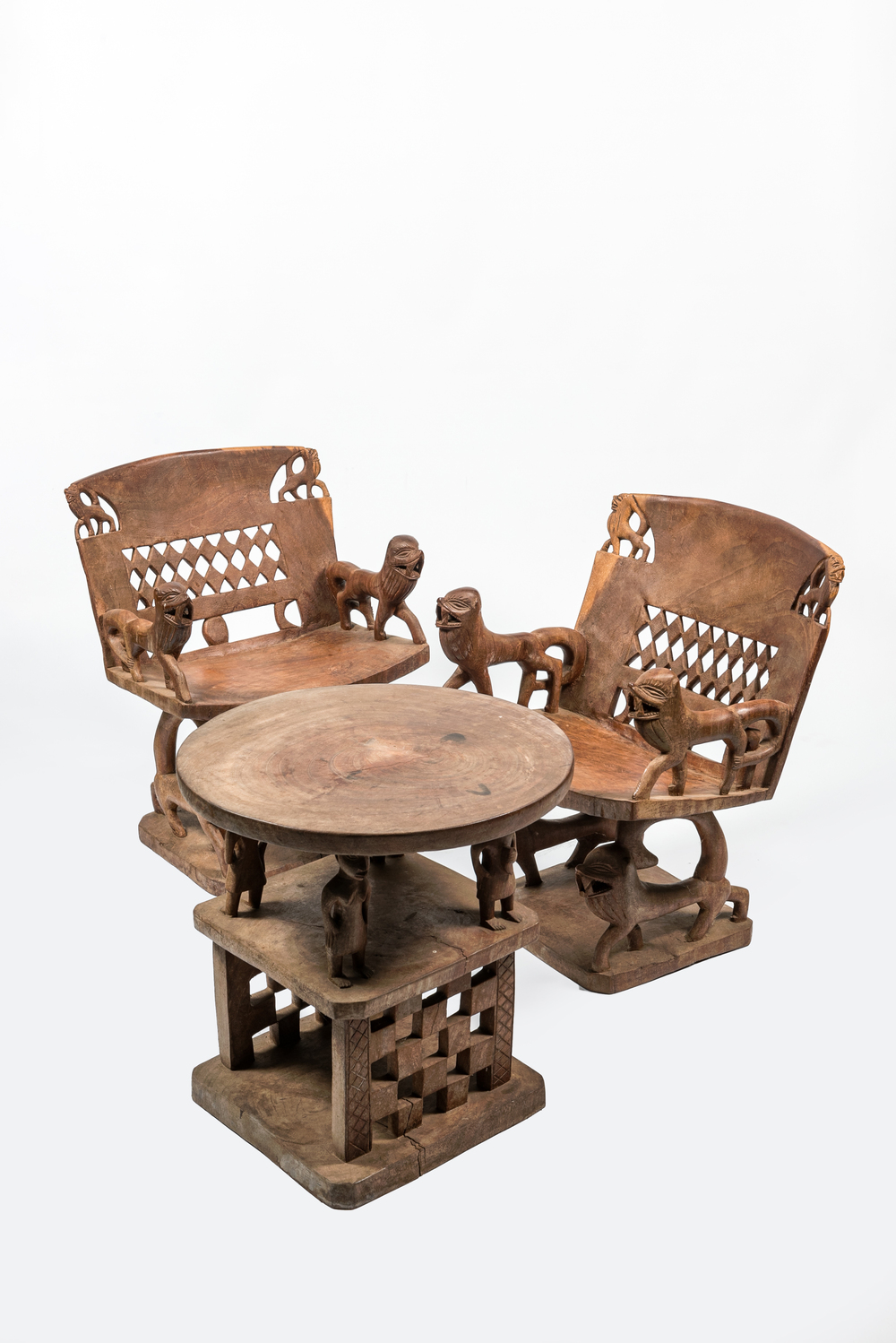Een Afrikaans houten salon bestaande uit twee stoelen en een bijzettafel, 20e eeuw