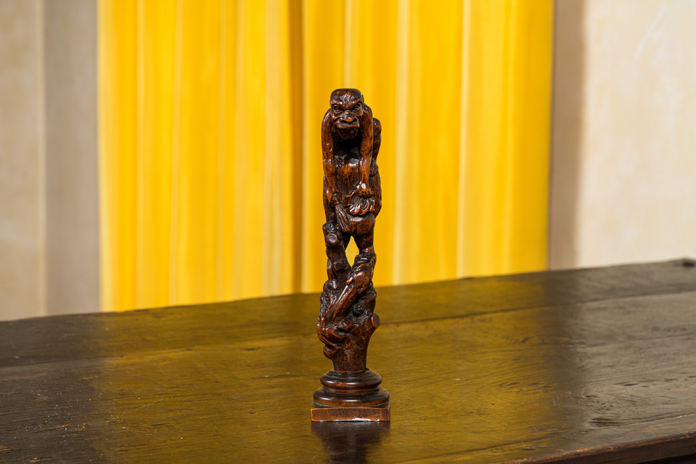 A wooden group with a pooping figure, 18/19th C.