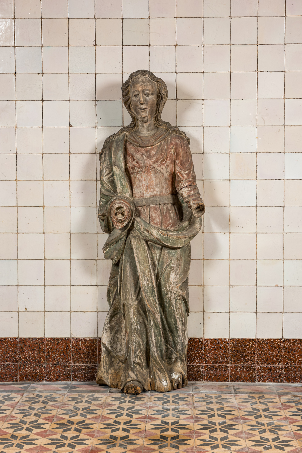 Een grote polychrome houten sculptuur van een vrouwelijke heilige, vroeg 17e eeuw