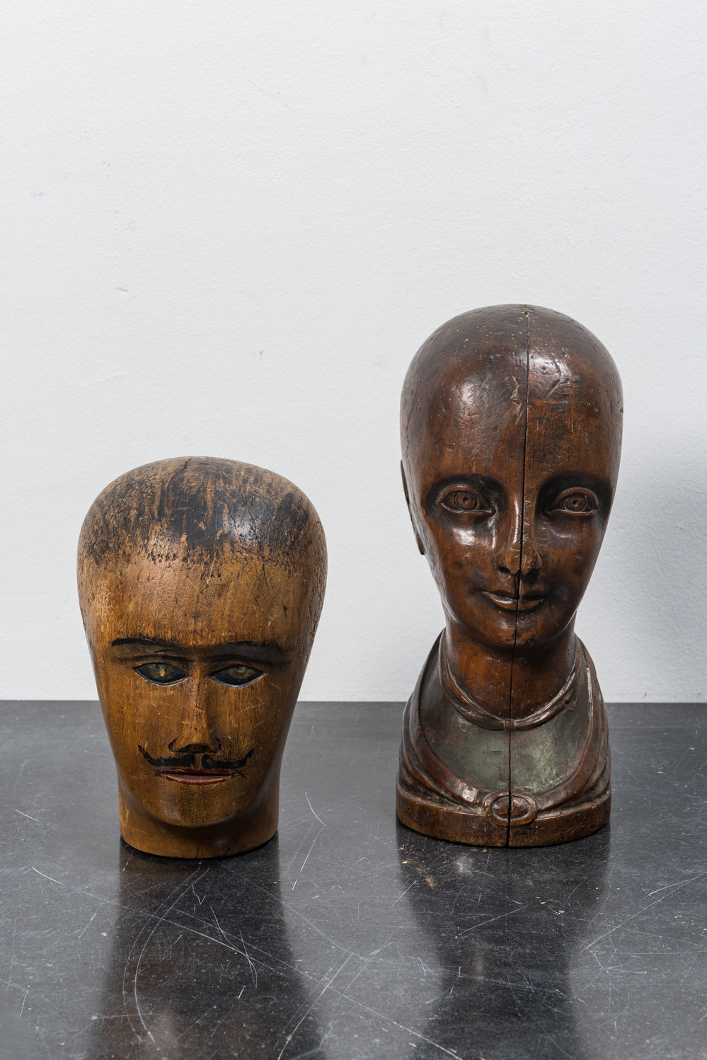 Two wooden head-shaped hat-shape models, 19th C.