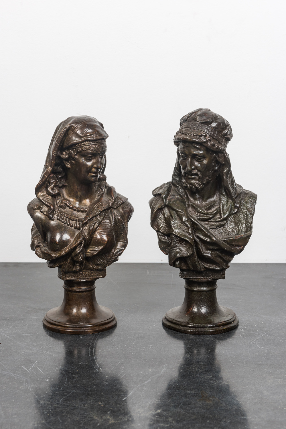 A pair of patinated bronze oriental subject busts, 19th C.