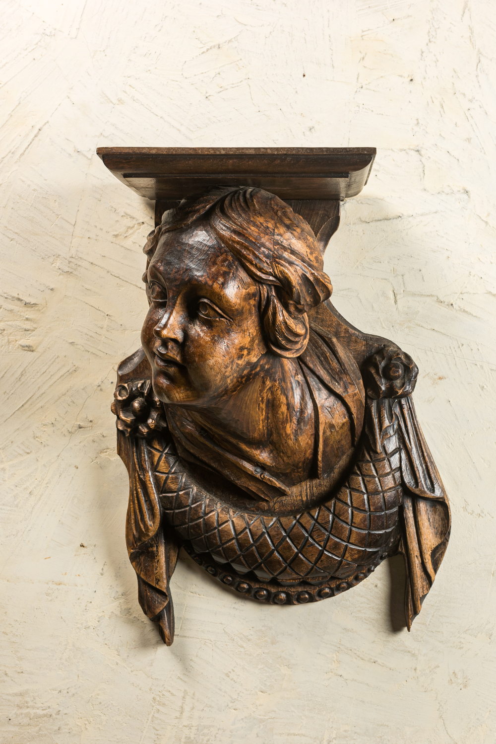 Een houten wandconsole met een meisjeshoofd, 17/18e eeuw