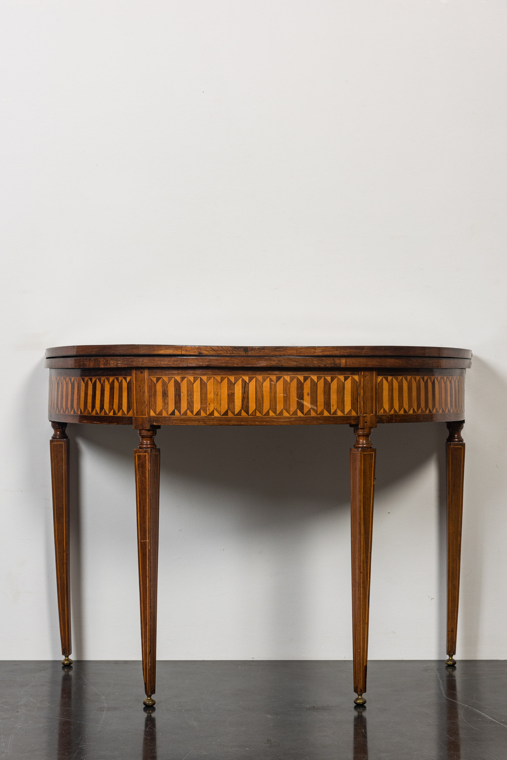 An Italian marquetry demi-lune gaming table with inlaid design of bow and arrows, 18/19th C.