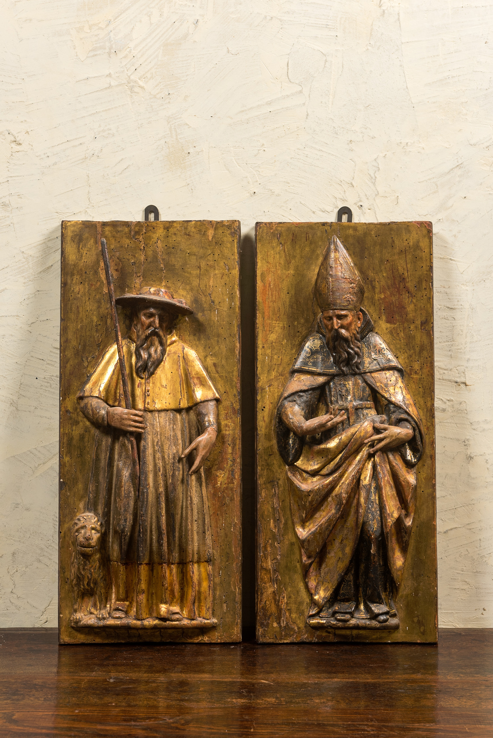Een paar polychrome houten reli&euml;fs met Sint-Antonius en een bisschop, 17e eeuw