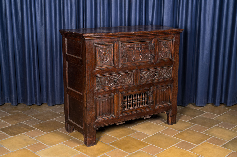 A Flemish carved oak two-door and two-drawer buffet with the Passion Instruments, dated 1691