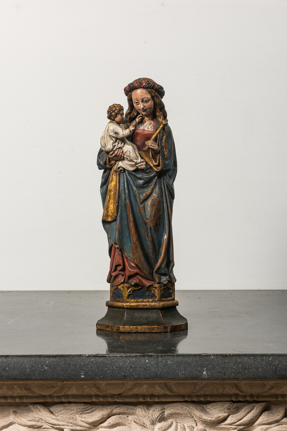 A polychromed wooden Madonna and Child on stand, 17th C.