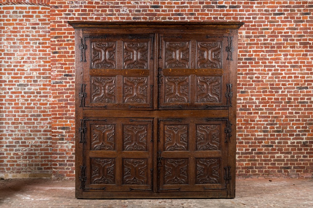 A rare large Flemish oak four-door cupboard with carved X-panels and wrought iron mounts, 1st half 16th C.