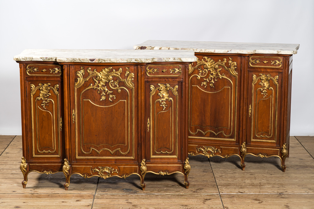 A pair of marble-topped partly gilded wooden side cabinets, 19/20th C.