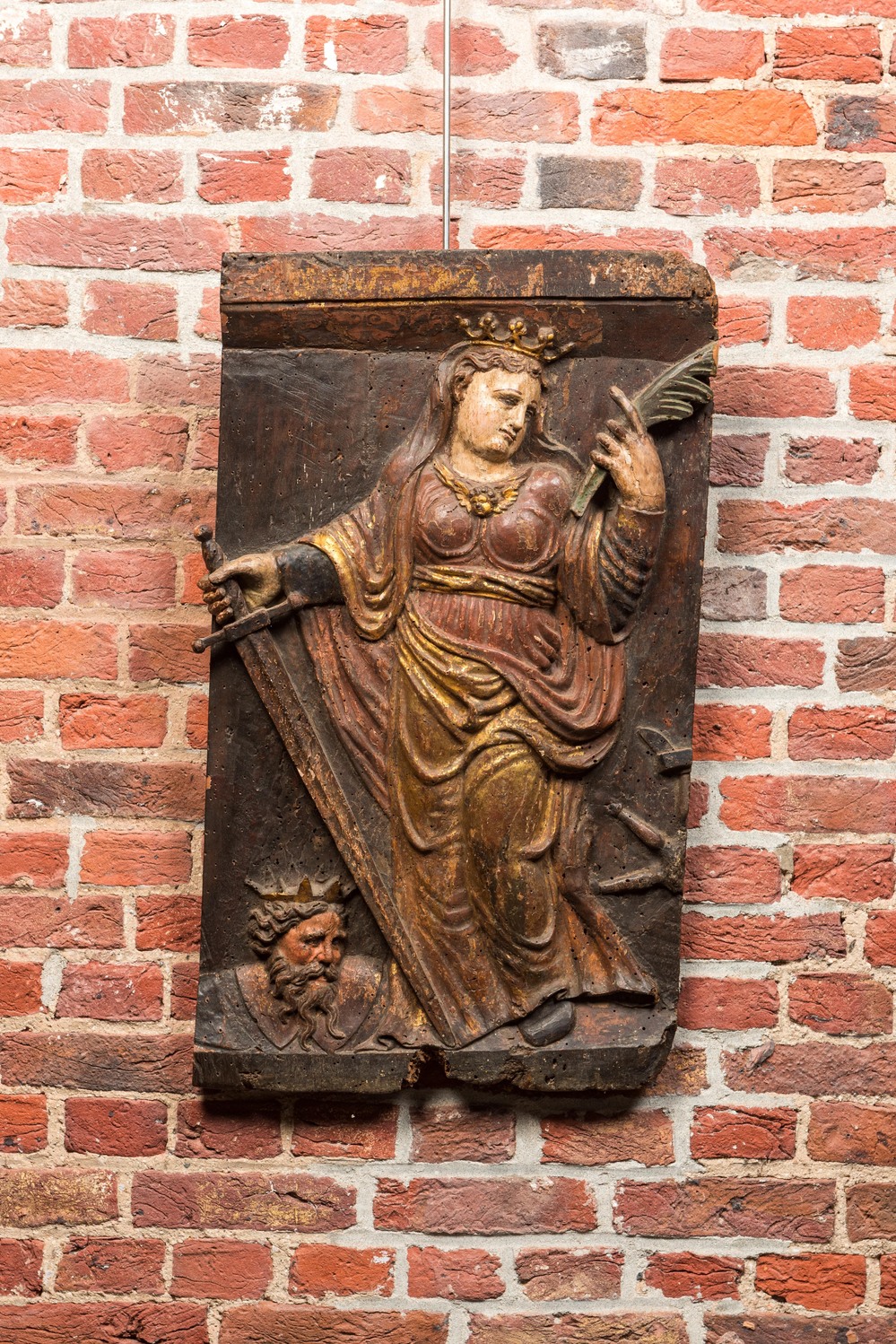 A Spanish polychrome oak panel with Catharine of Alexandria and emperor Maxentius, 17th C.