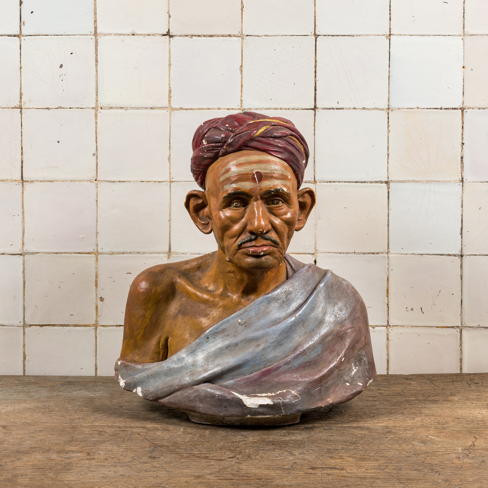 A polychrome plaster bust of an Indian wearing a turban, illegibly signed, dated 1925