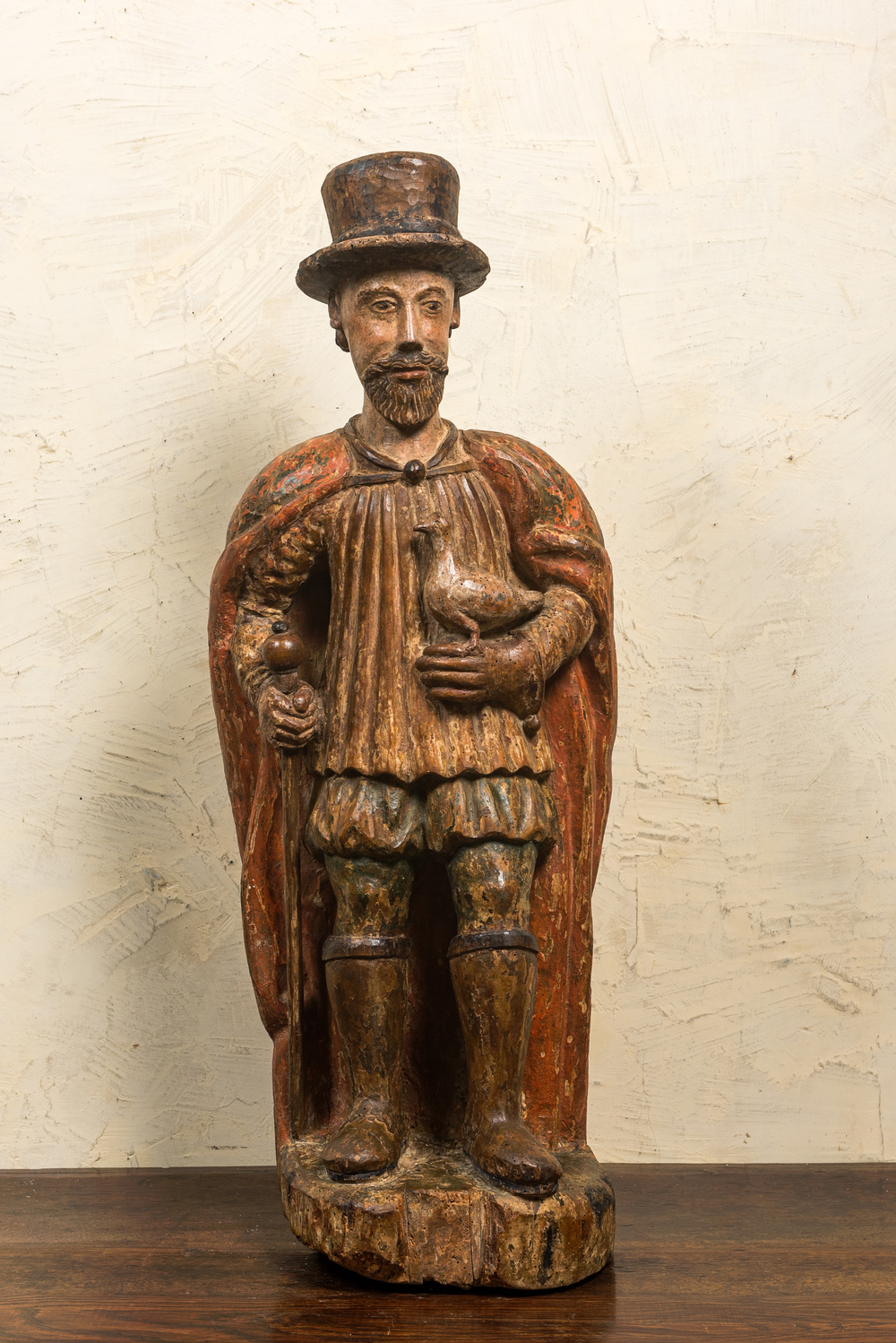 Een Spaanse polychrome notenhouten figuur van een edelman met een duif, 16/17e eeuw