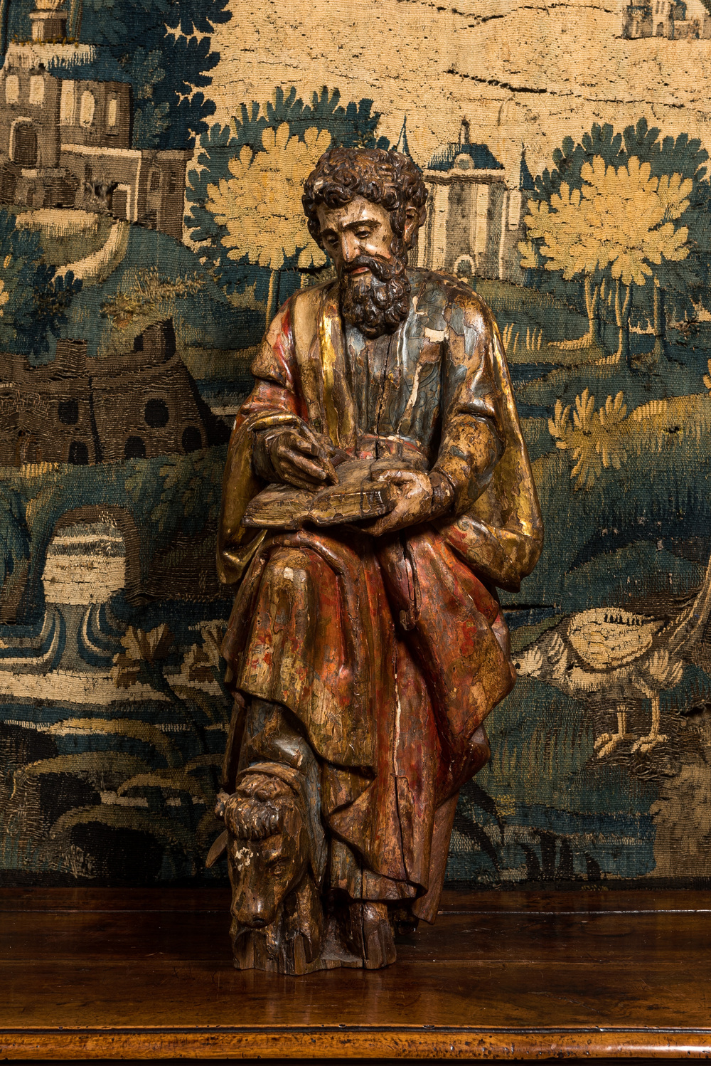 A Spanish polychromed walnut sculpture of Saint Luke, 16th C.