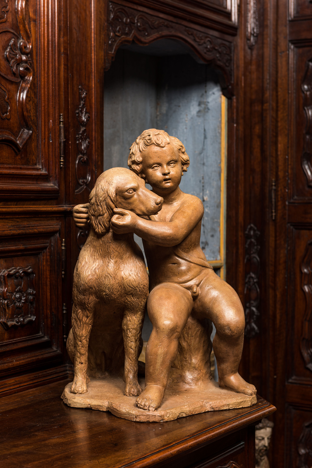 Groupe en terre cuite figurant un putto &agrave; c&ocirc;t&eacute; d'un chien, 19&egrave;me