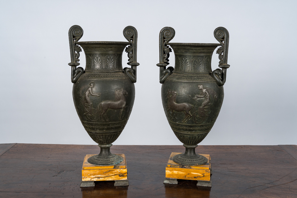 A pair of neoclassical style vases with charioteers on a Siena marble base, 19/20th C.