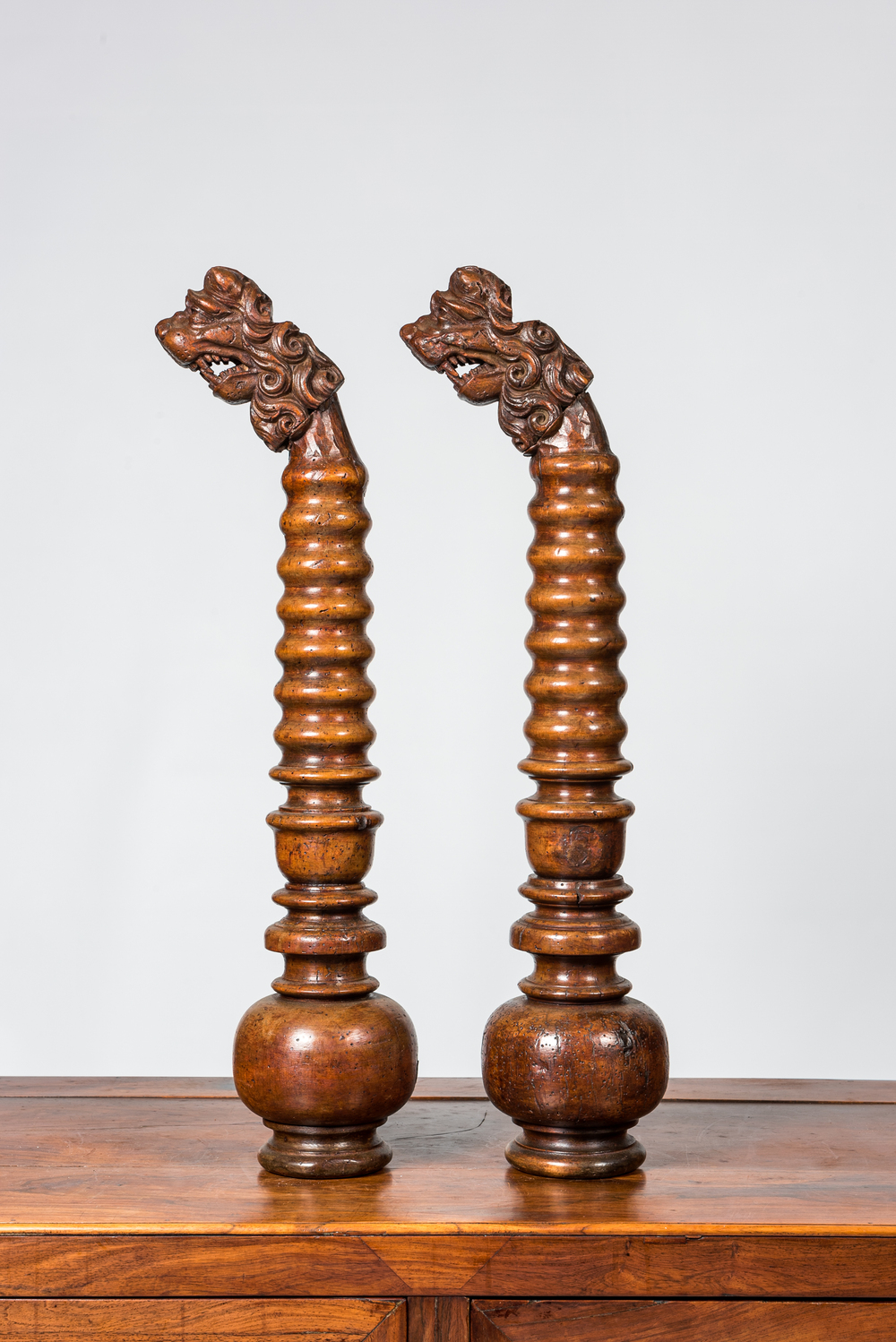 A pair of Italian baluster-shaped elements topped with lions' heads, 17/18th C. and later