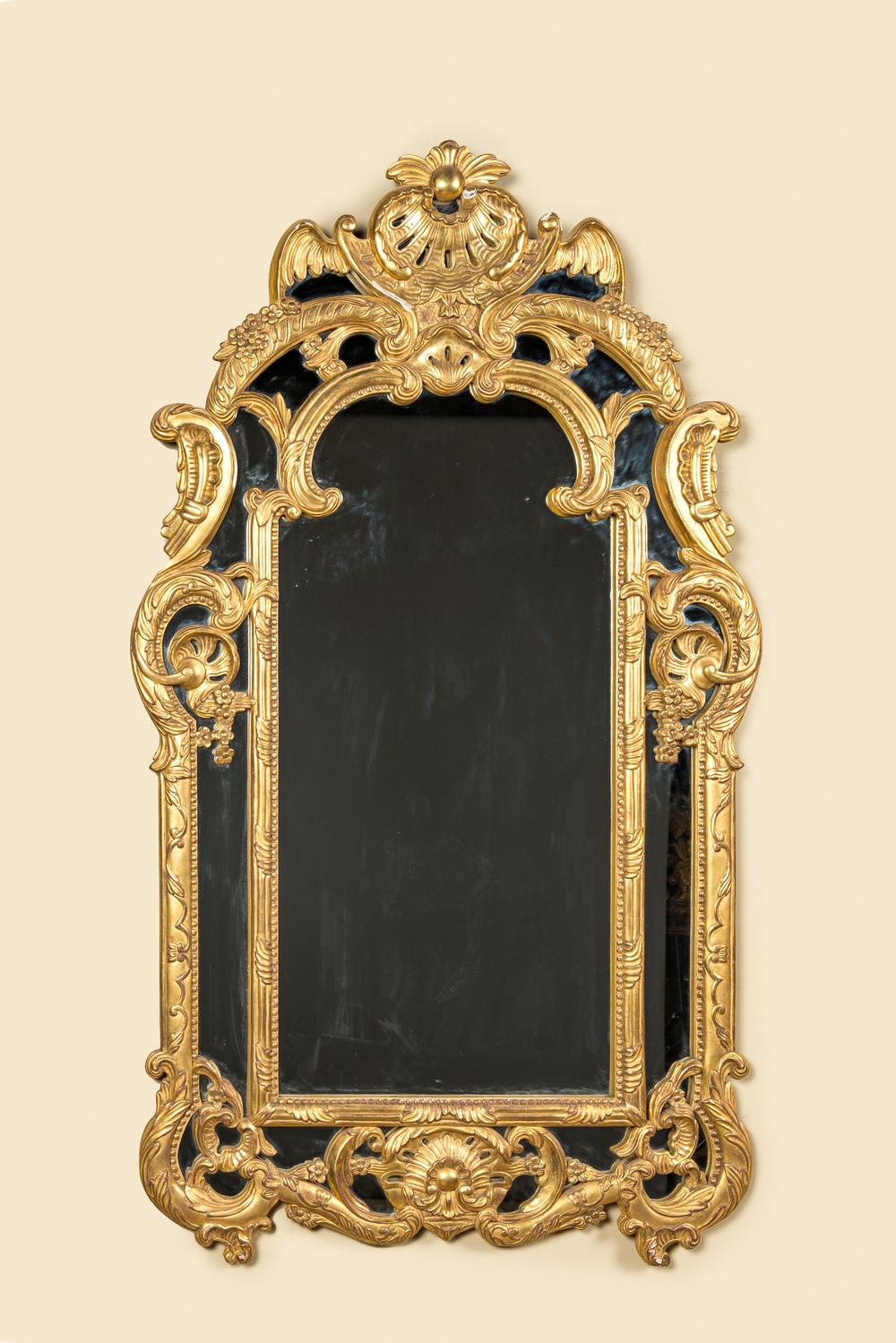 A French carved and gilt wooden mirror, 19th C.