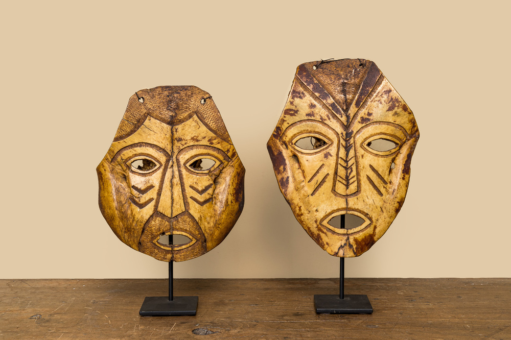 A pair of tortoiseshell masks on a metal base, 20th C.