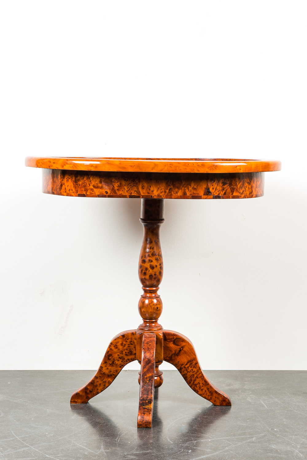 An oval side table with rootwood veneer and parquetry, 20th C