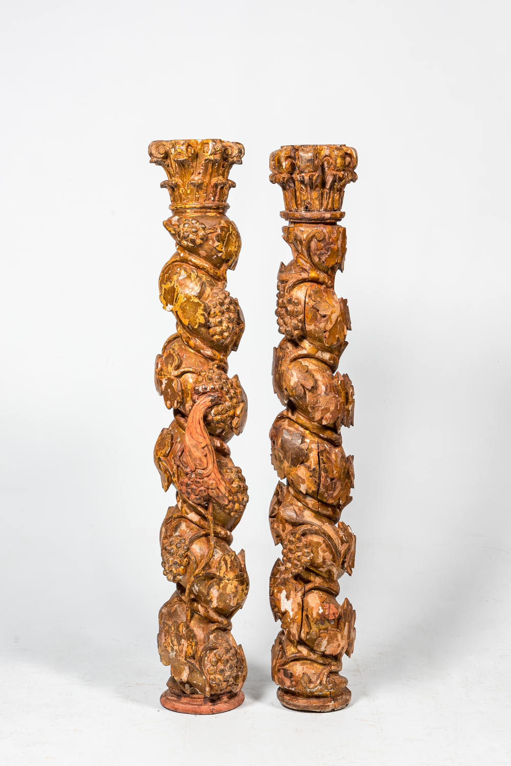 Een paar polychrome en vergulde houten kolommen met druivenranken, 17/18e eeuw