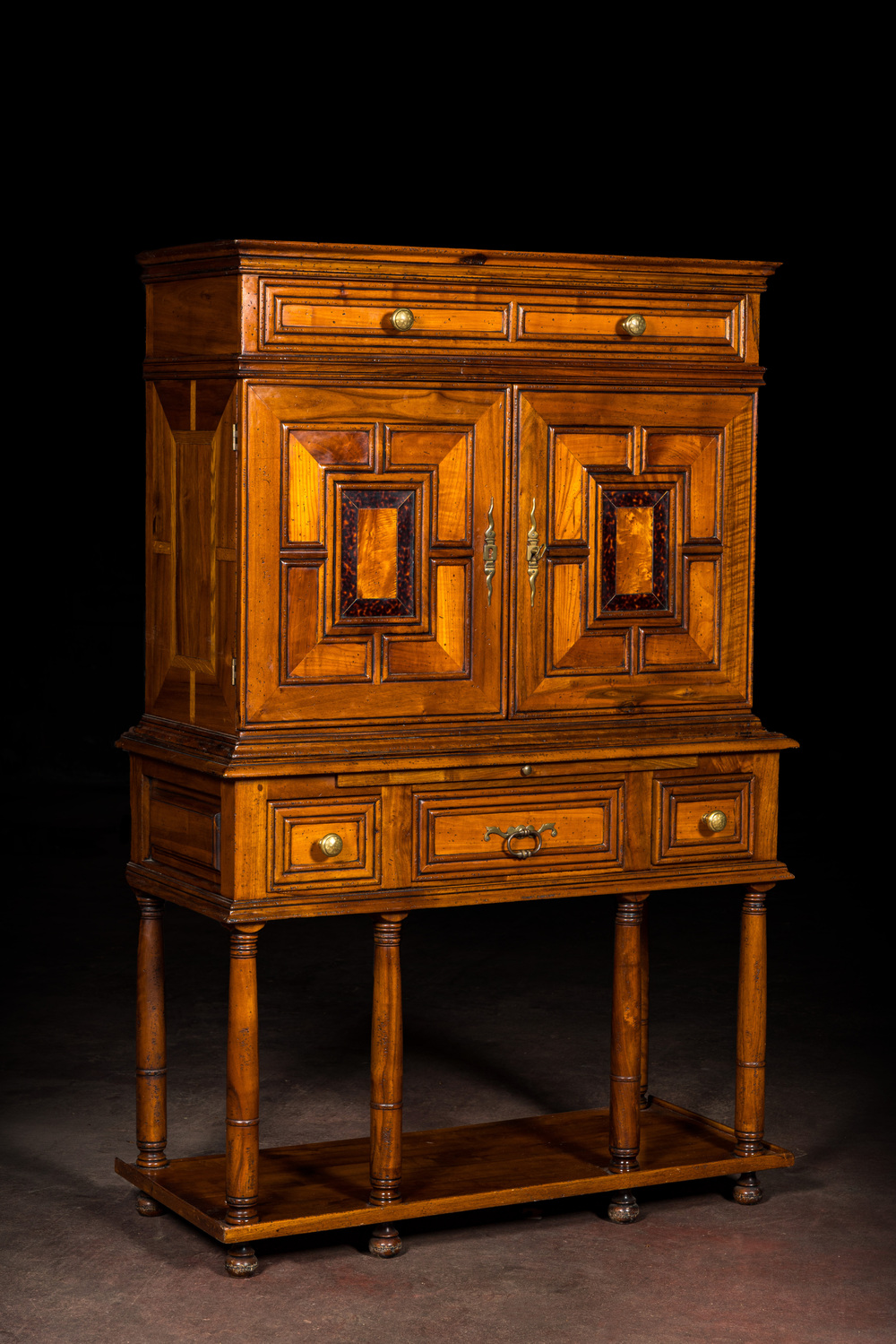 A cabinet on foot in various woods inlaid with faux tortoiseshell, 20th C.