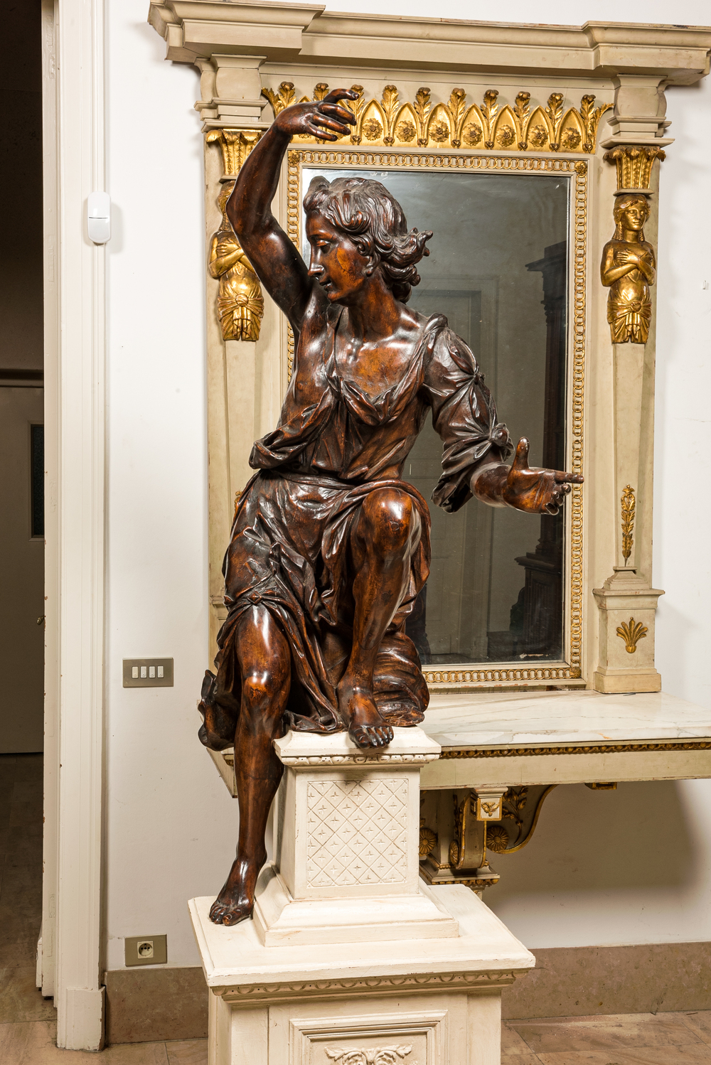 A large walnut figure of an angel, Flanders, 17th C., on a later stand