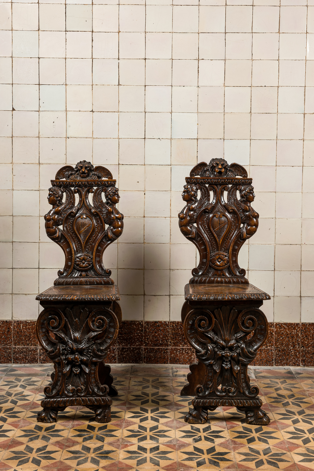 Une paire de chaises de type 'sgabello' en bois &agrave; d&eacute;cor de mascaron, Italie, 19&egrave;me