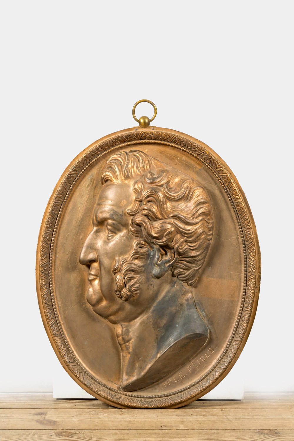 A gilt bronze plaque with a profile portrait of a man, 19th C.