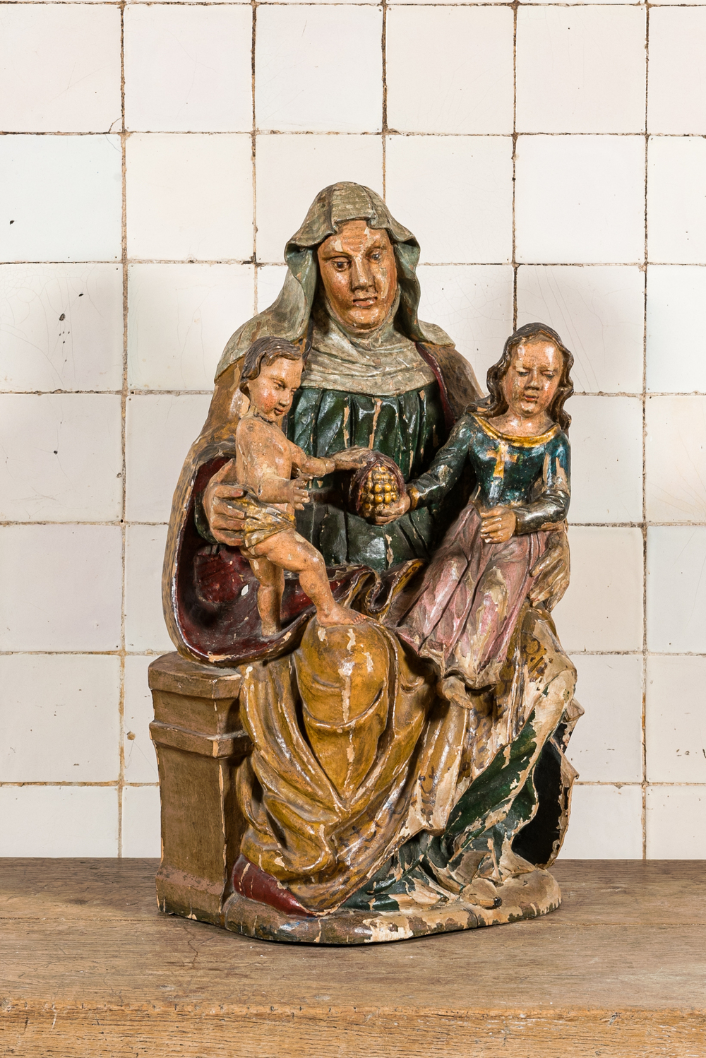 Een polychrome houten Sint-Anna-ten-drie&euml;n met granaatappel, 17e eeuw