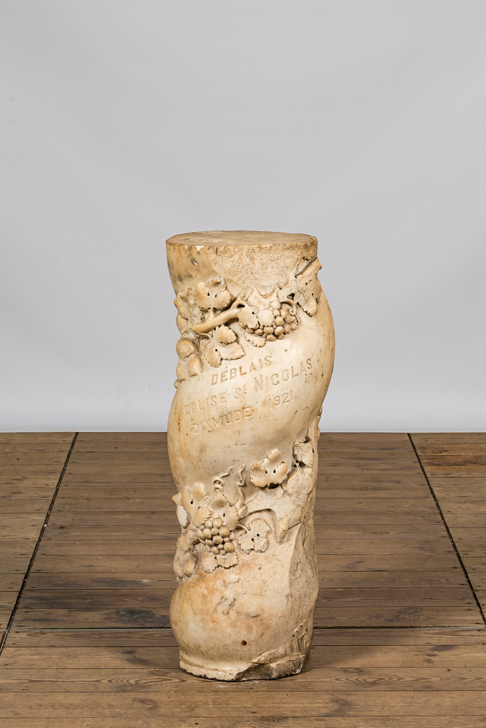 Une colonne torsad&eacute;e en marbre blanc &agrave; d&eacute;cor floral et inscription 'D&eacute;blais Eglise St Nicolas Dixmude 1921', 18&egrave;me et apr&egrave;s