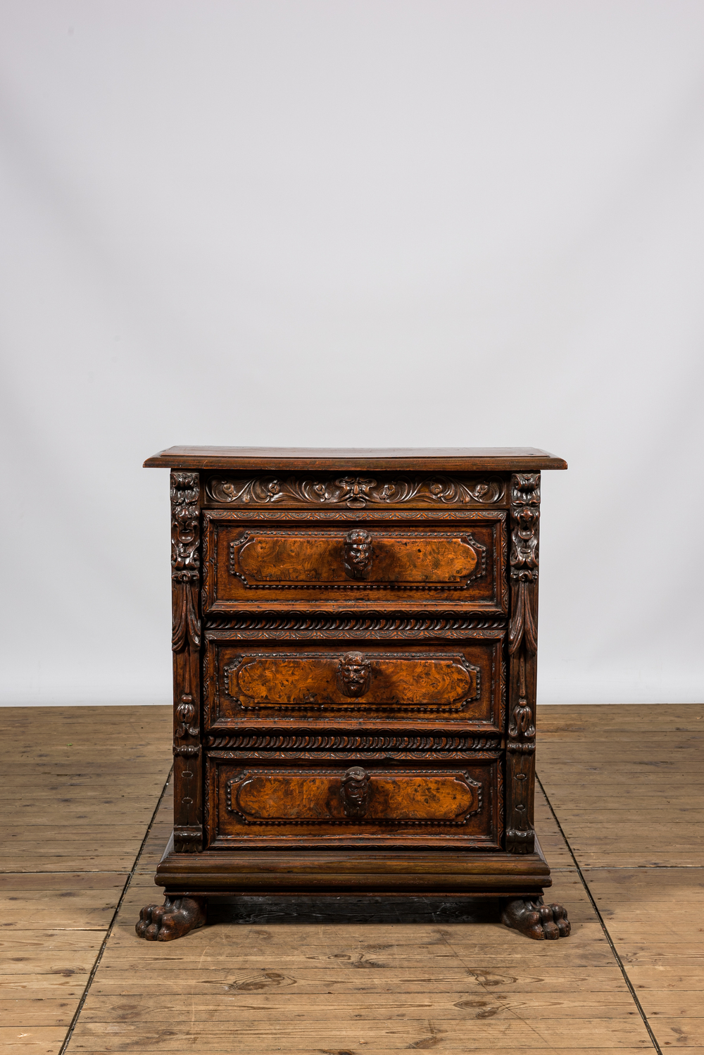 An Italian richly decorated walnut and burl wood chest of drawers with mascarons, 19th C.