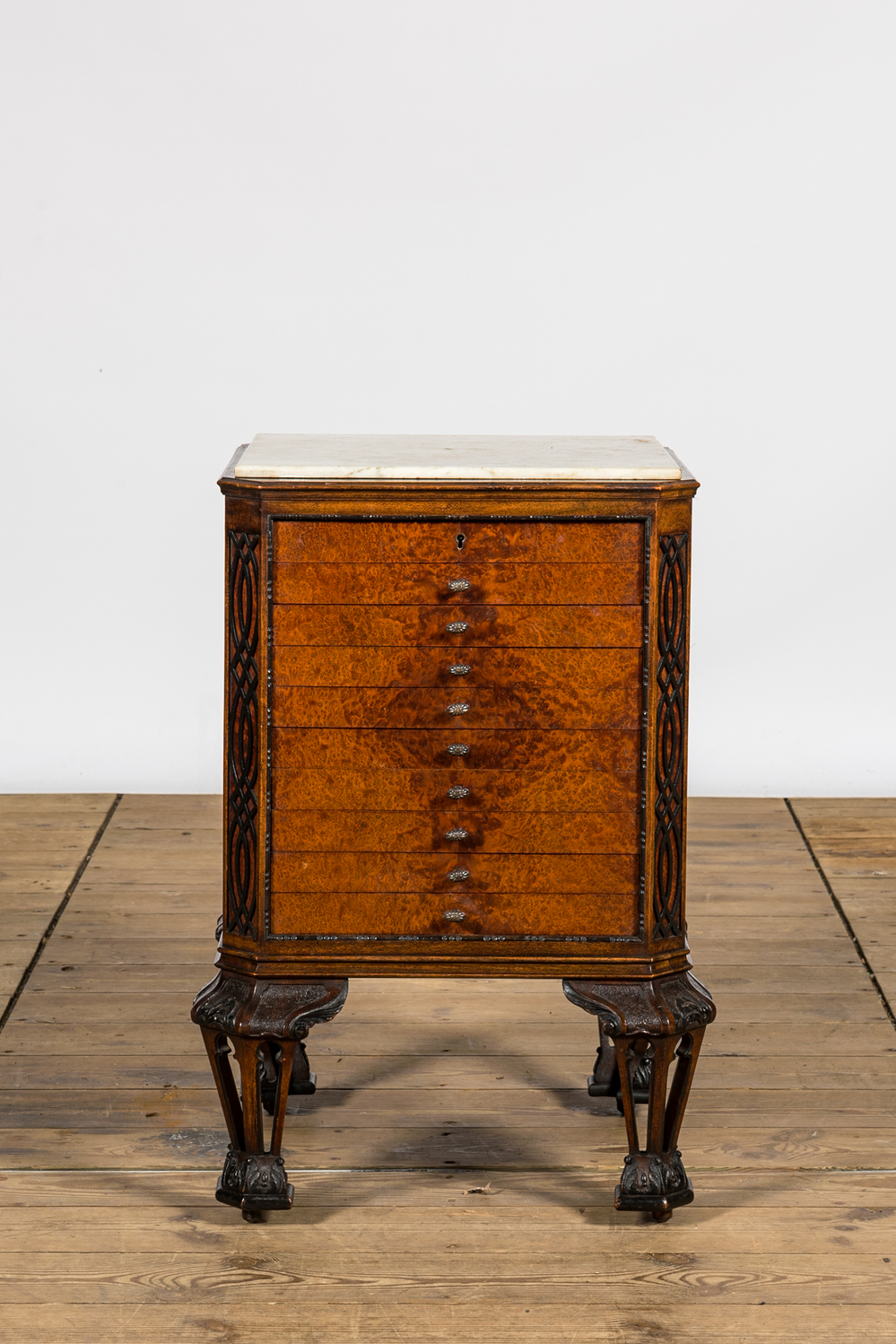 A burl wood veneered coin cabinet with marble top, 20th C.