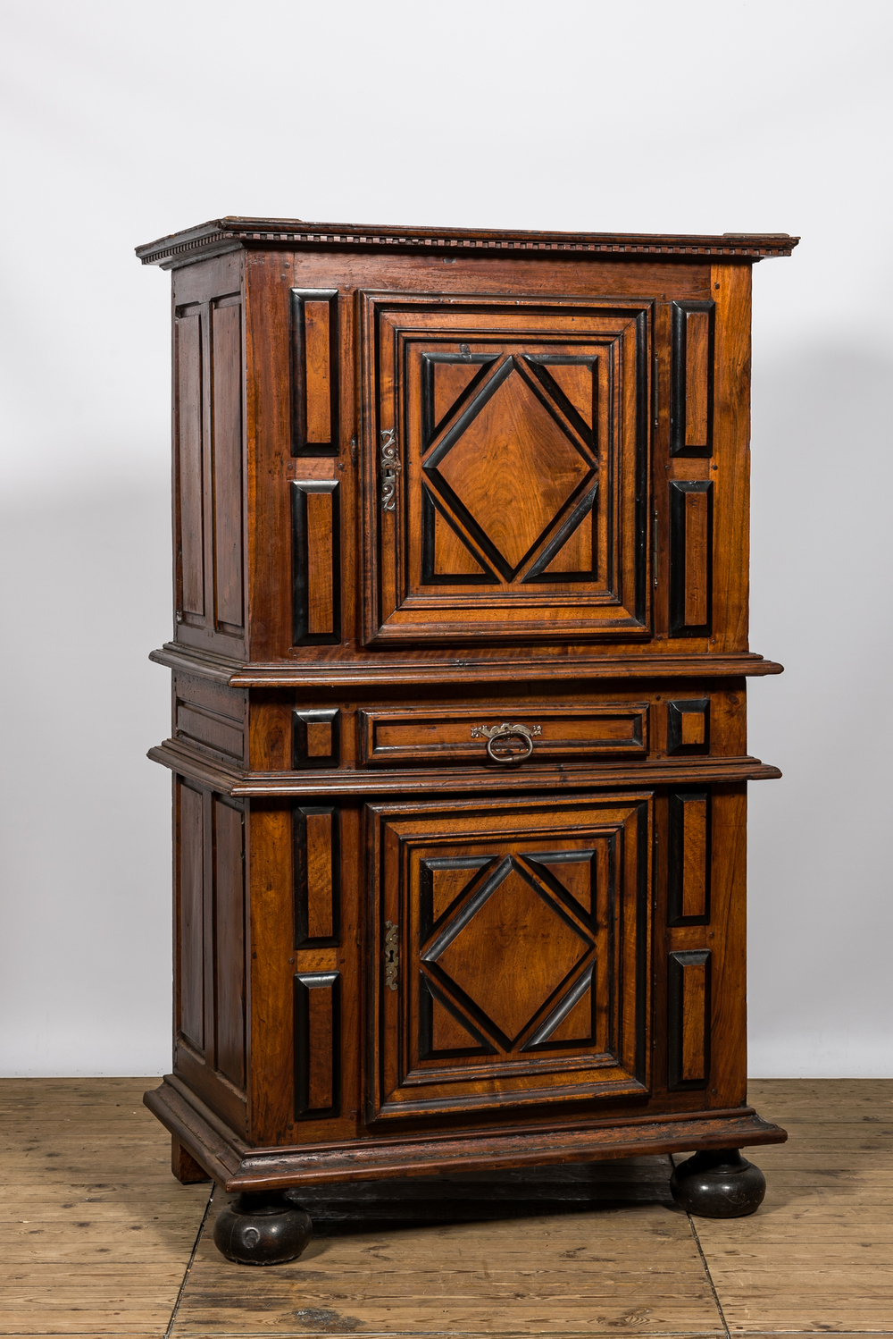 A walnut two-door cabinet with ebonised accents, 17th C.