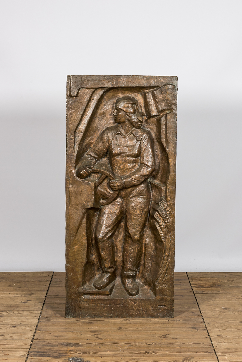 Een groot bronzen communistisch reli&euml;f met een arbeider, mogelijk Oost-Europa, 3e kwart 20e eeuw