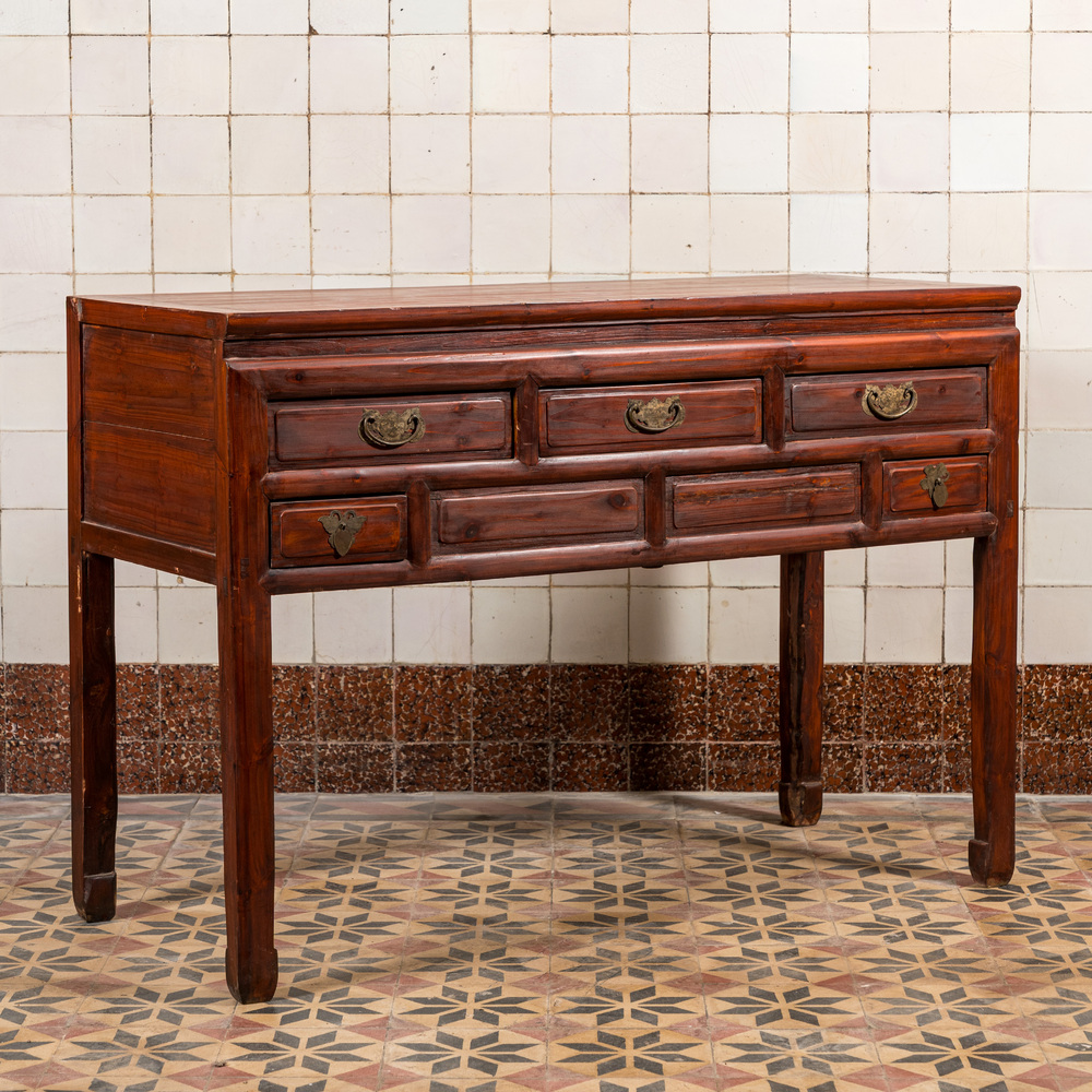 A Chinese wooden side table with drawers, 20th C.