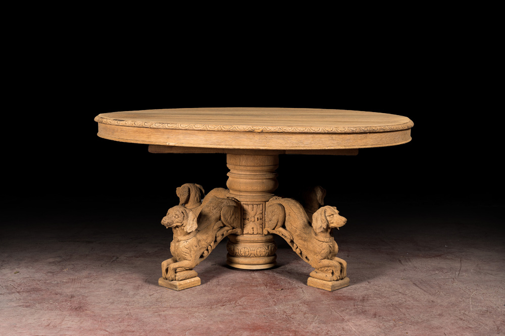 Table ovale en ch&ecirc;ne blanchi sur une base centrale richement sculpt&eacute;e &agrave; d&eacute;cor de chiens, 19&egrave;me