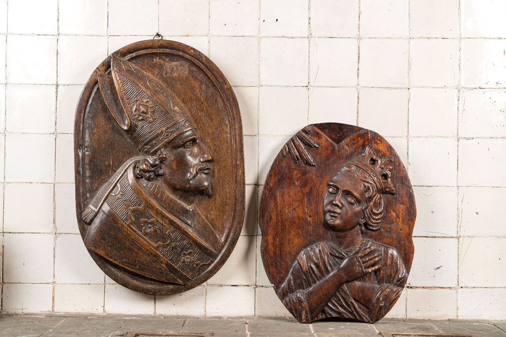 Twee ovale houten reli&euml;fmedaillons met een bisschop en de annunciatie, 17/18e eeuw