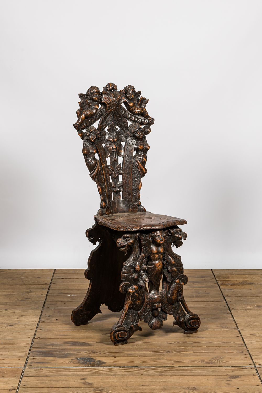 A richly carved Italian walnut sgabello, 19th C.