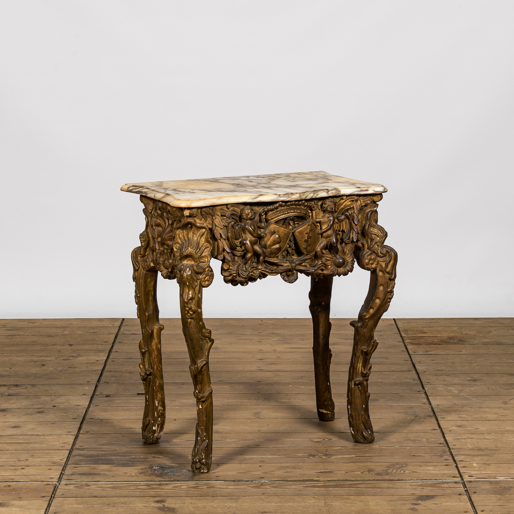 A gilt wooden console with putti and blazons and a marble top, 19th C.