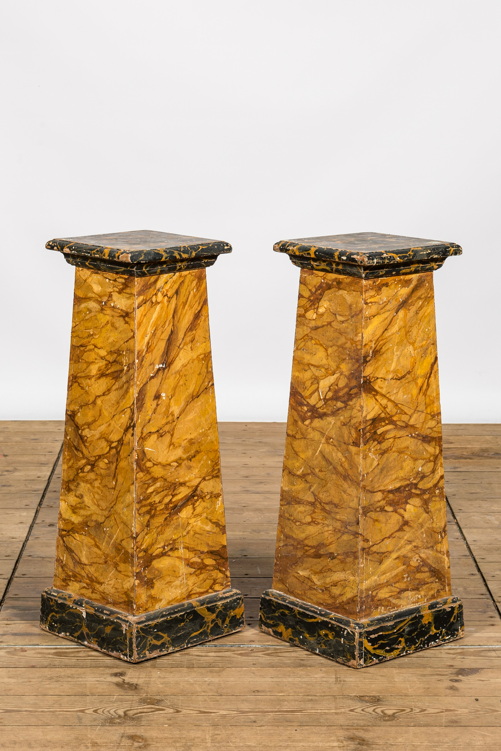 A pair of faux-marbre wooden pedestals, ca. 1900