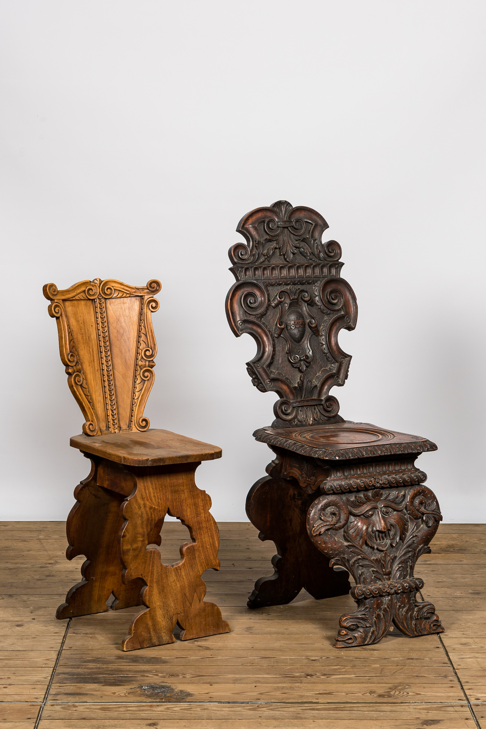 Twee Italiaanse houten sgabello's, waarvan &eacute;&eacute;n met mascarons, 19/20e eeuw