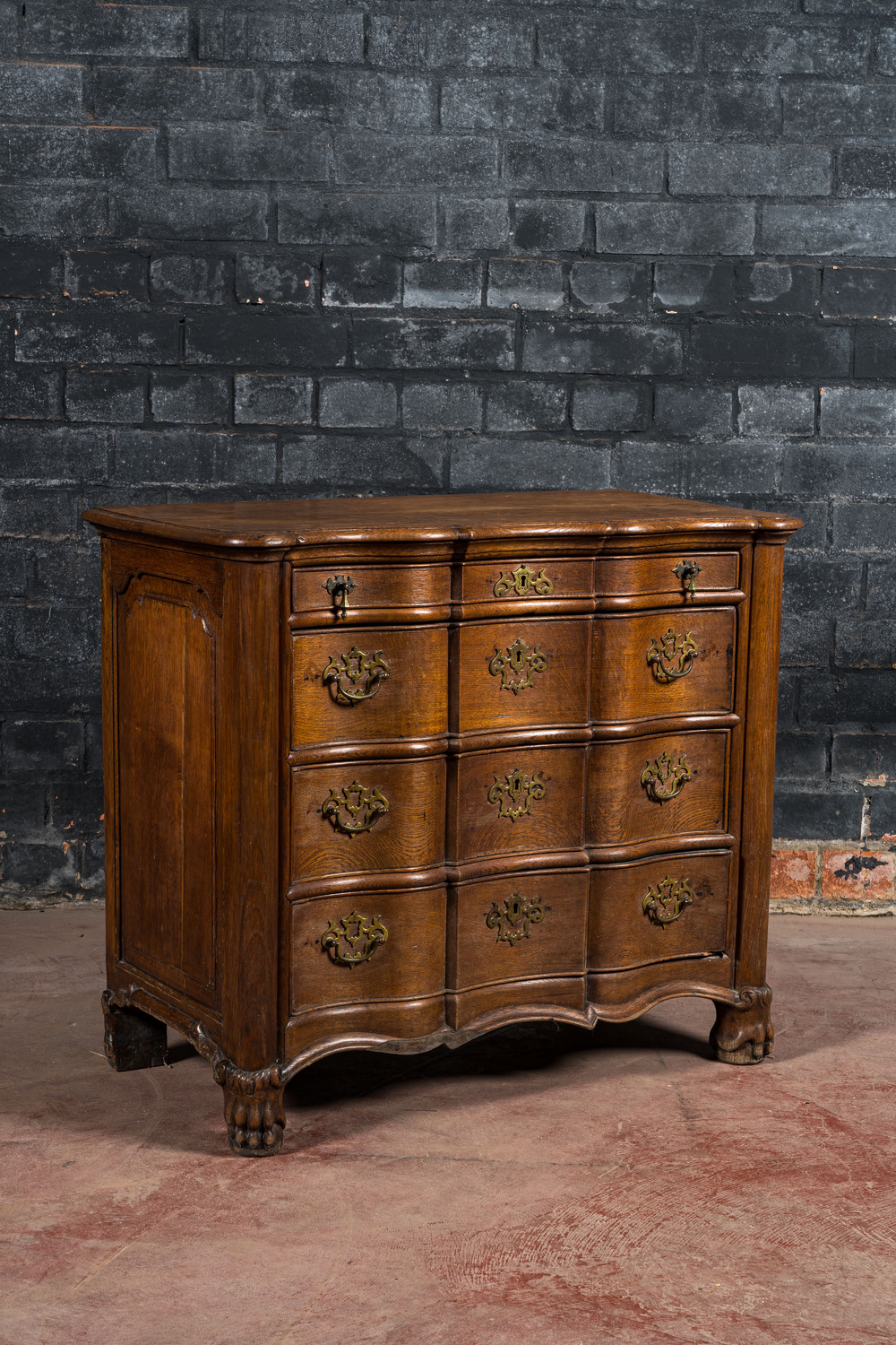 A French Louis XV-style oak commode on lion paw stands, 19th C.