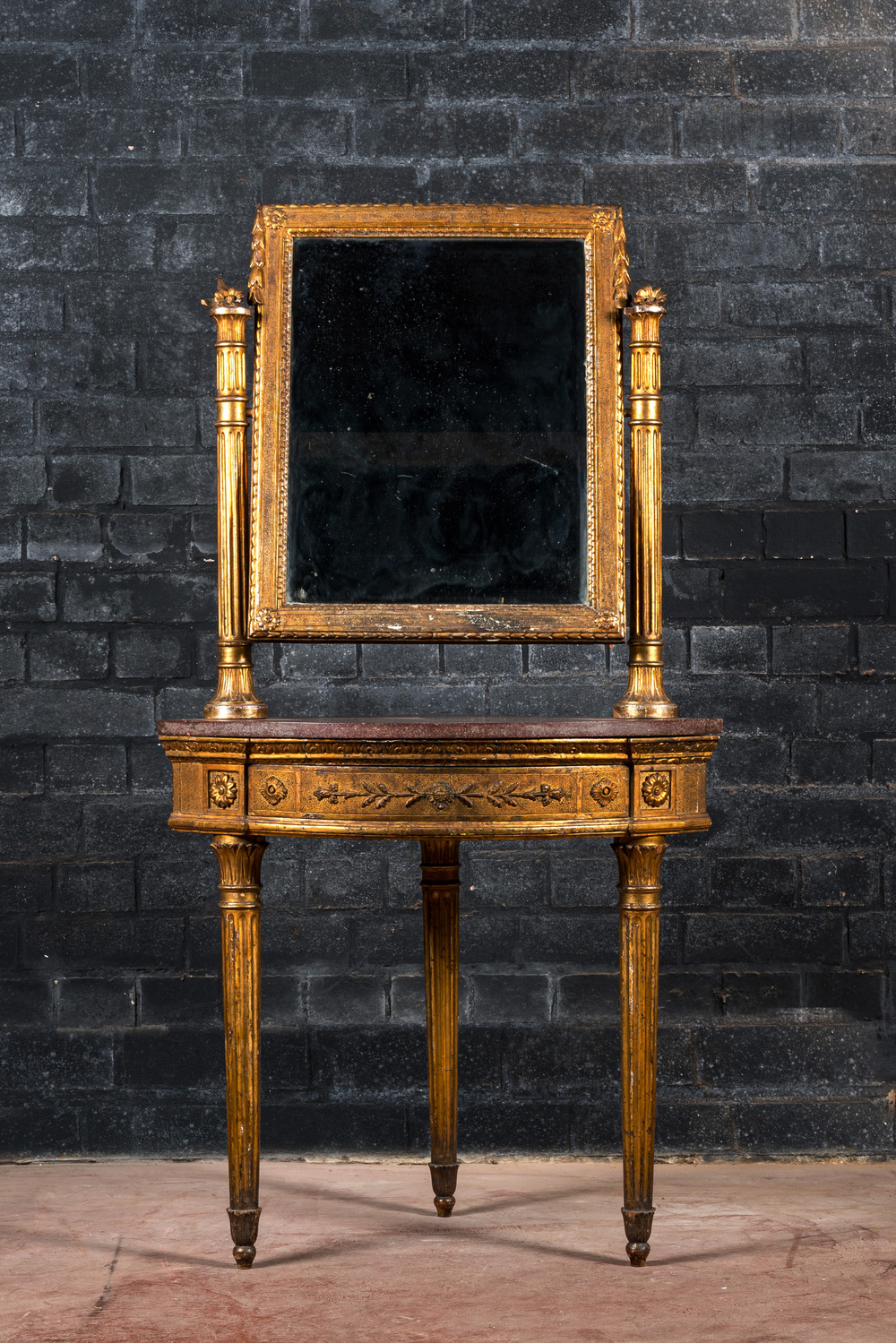 Een neoclassicistische vergulde hoekconsoletafel met marmeren blad bekroond met een spiegel, 19e eeuw