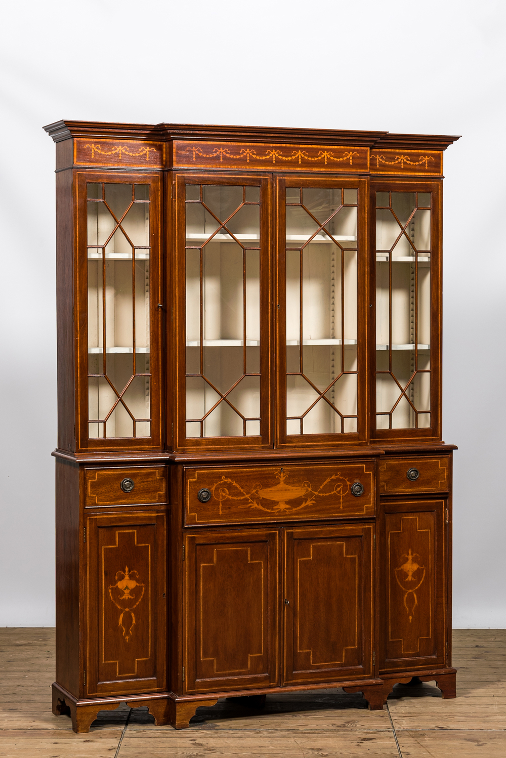 An English neoclassical mahogany marquetry breakfront bookcase, 19/20th C.