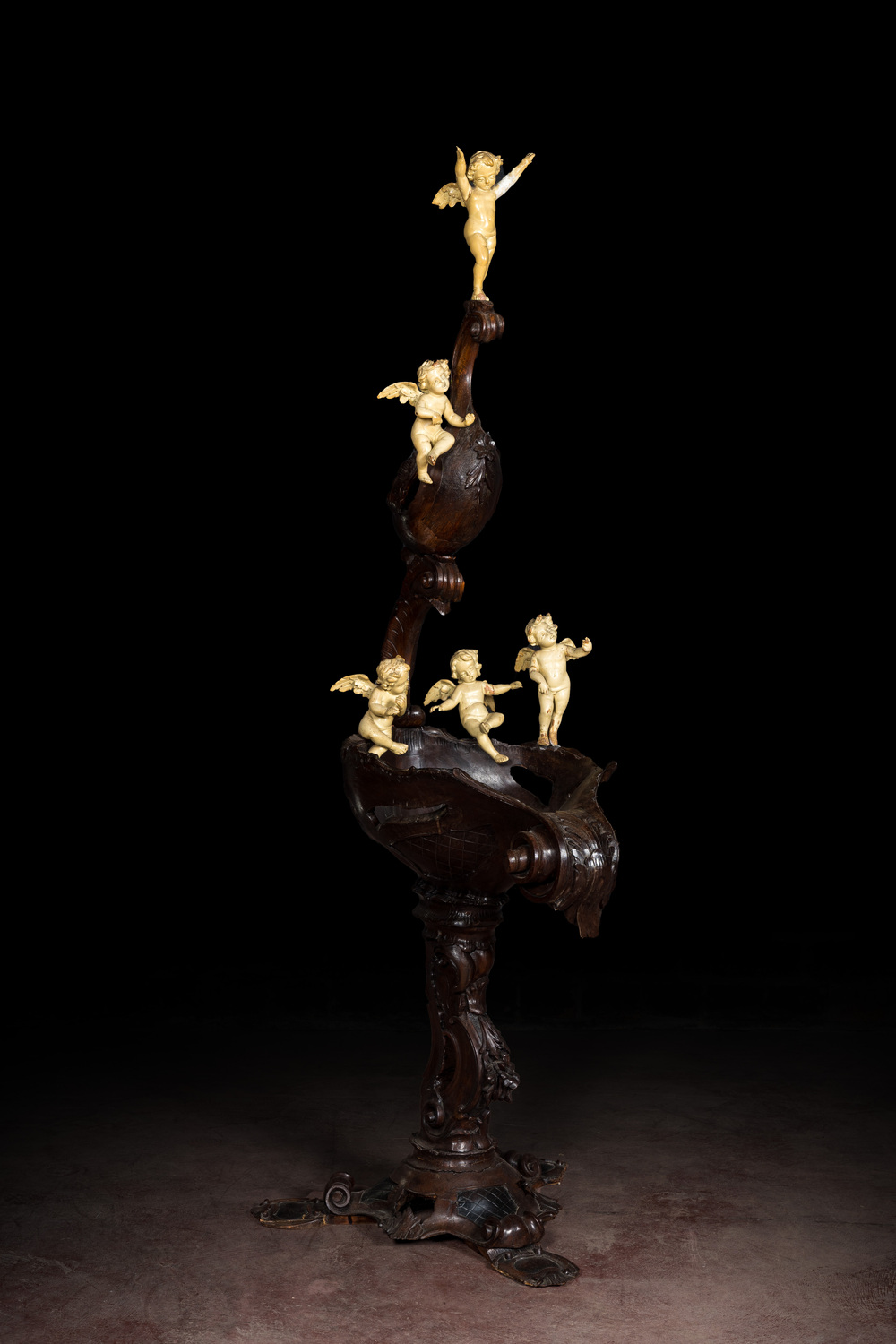 A richly carved walnut jardini&egrave;re or stand with angels, 19th C.