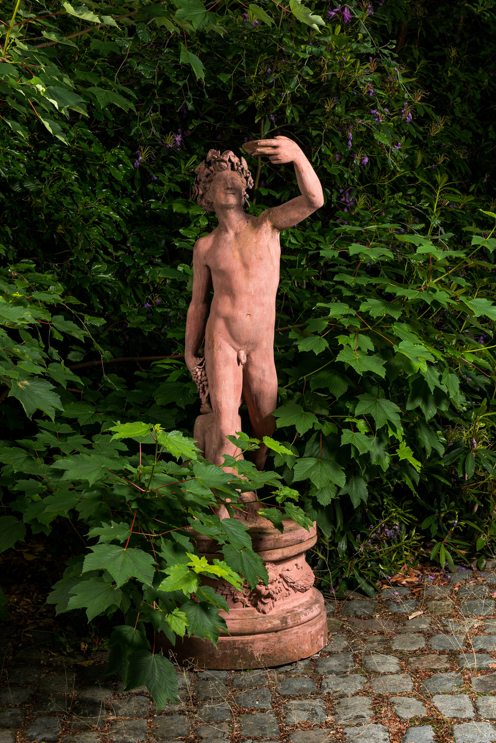 A large patinated terracotta sculpture of a bacchant with a young satyr, 20th C.