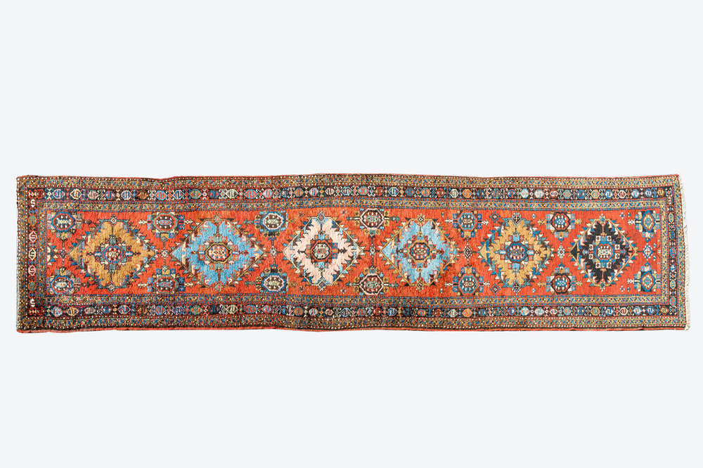 Een lange oosterse wollen loper met geometrische motieven en floraal decor, 20e eeuw
