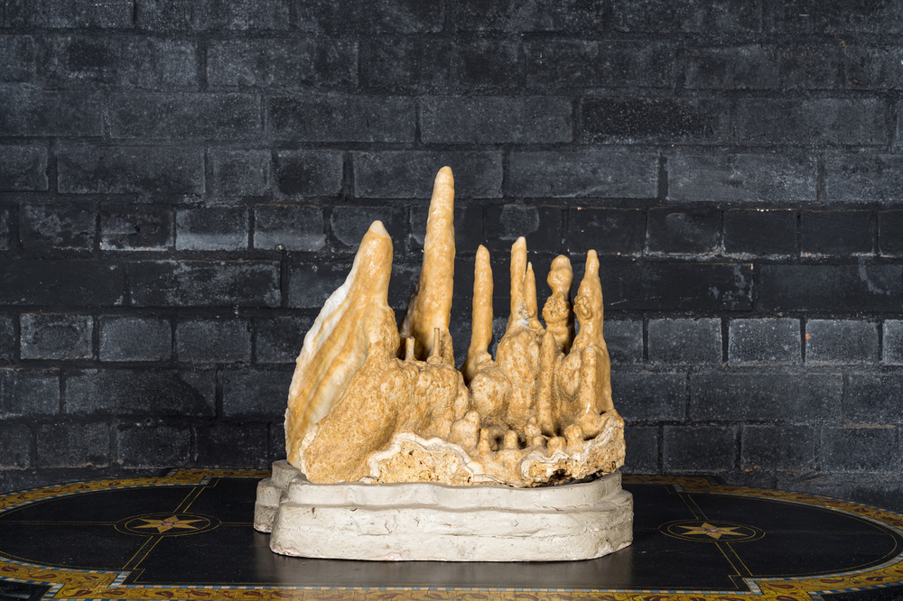 A large stalactites specimen on a painted wooden base