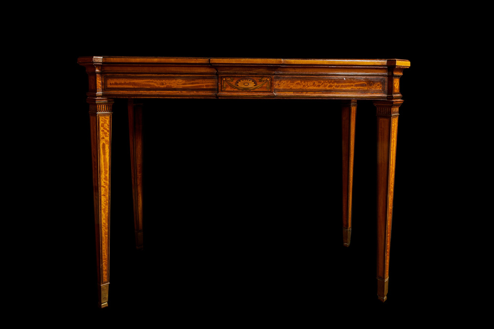 An inlaid wooden Empire-style table with brass mounts on the legs, probably France, 19th C.