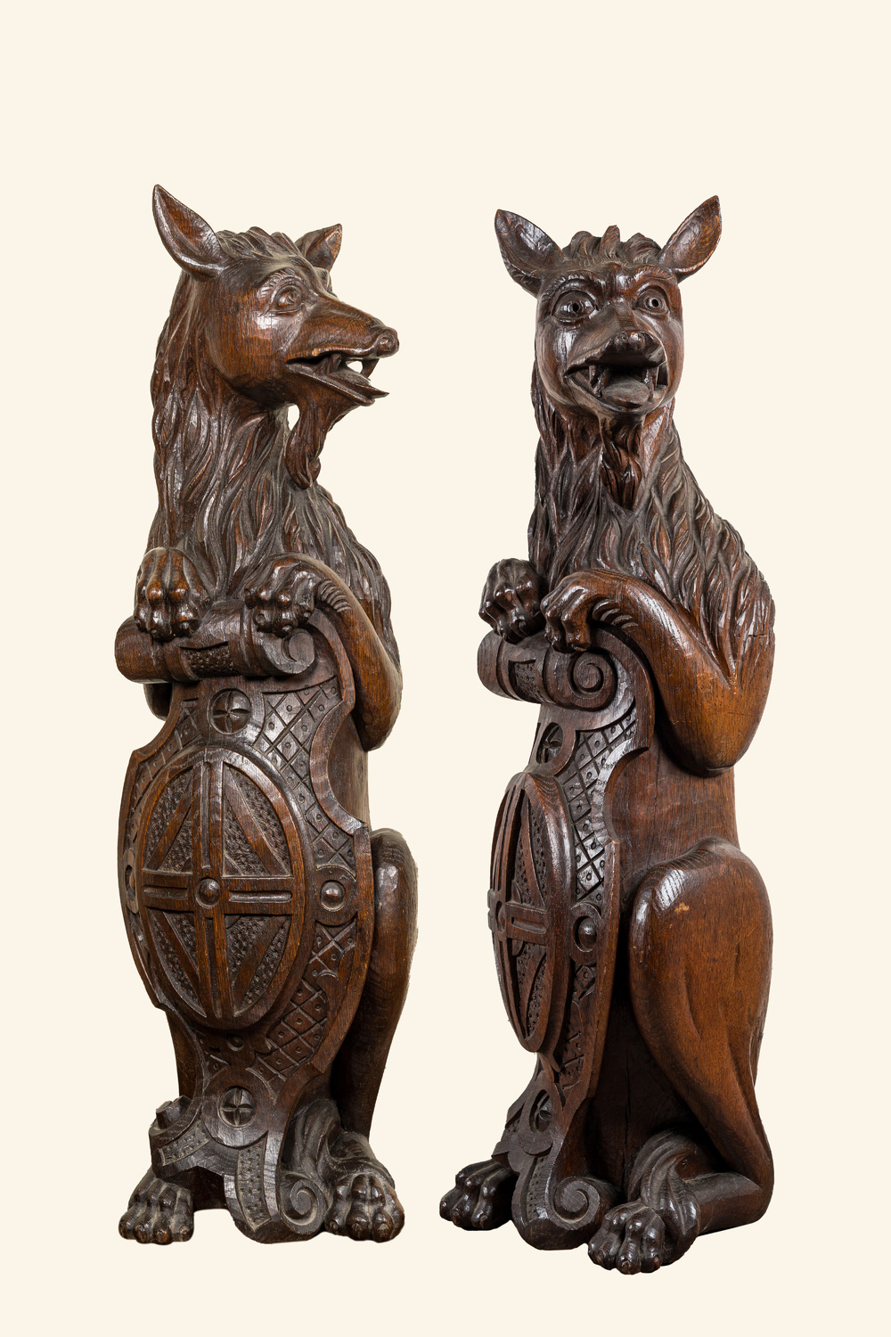 Two oak sculptures of mythical creatures with a shield, 19th C.